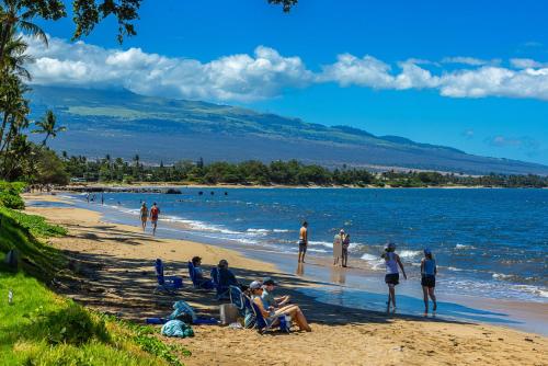 a group of people sitting on a beach at Nani Kai Hale 604 by Coldwell Banker Island Vacations in Kihei