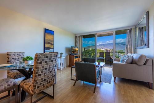 a living room with a couch and a table and chairs at Nani Kai Hale 502 by Coldwell Banker Island Vacations in Kihei