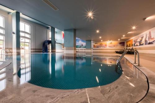 a large swimming pool with a slide in a building at Hotel Vila Galé Cerro Alagoa in Albufeira