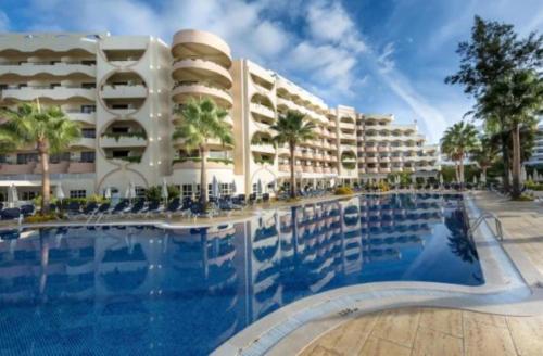 a hotel with a swimming pool in front of a building at Hotel Vila Galé Cerro Alagoa in Albufeira