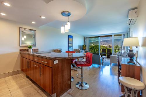 a kitchen with a island with a table and chairs at Nani Kai Hale 502 by Coldwell Banker Island Vacations in Kihei