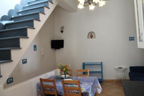 a dining room with a table with chairs and stairs at Casa Marietta in Lipari