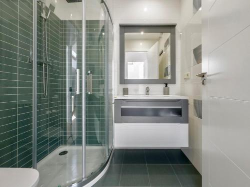 a bathroom with a glass shower and a sink at Atticus in Toledo
