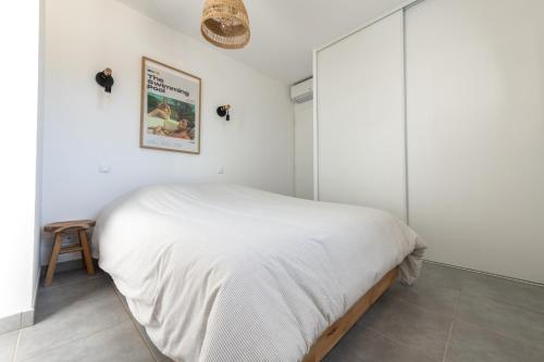 - une chambre avec un lit et une couverture blanche dans l'établissement La Piscine - Maison de vacances dans Le Golfe de Saint Tropez - 6 personnes, à Cogolin