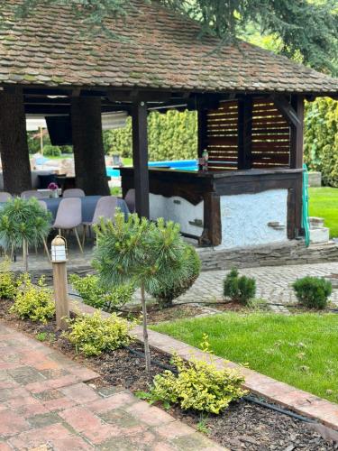 a garden with a gazebo with a table and chairs at Vila Aleksić in Smederevo