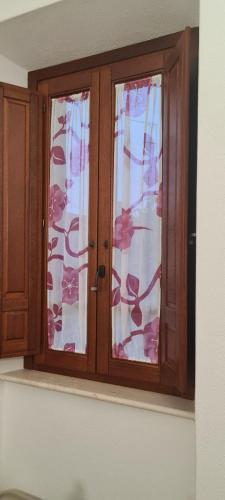 a wooden window with curtains in a room at La casa di nonno in Ghilarza