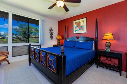 a bedroom with a blue bed and red walls at Grand Champions 164 by Coldwell Banker Island Vacations in Wailea