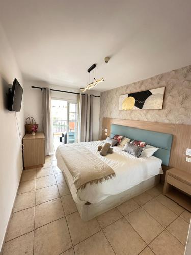 a bedroom with a large bed and a tv at Royal Palace- Granada Park in Arona