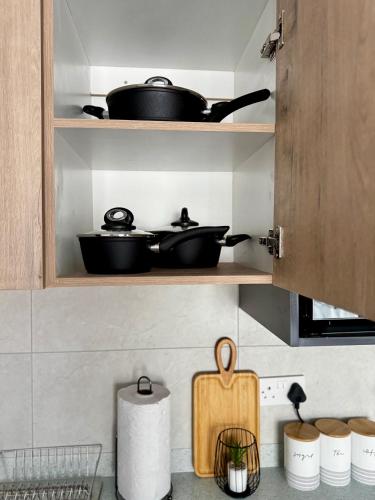 a kitchen with two pots and pans on shelves at Motswedi Place Apartments K10 - Harmony Bliss in Gaborone
