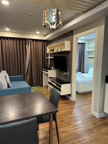 a living room with a couch and a table and a bedroom at Dusit Grand Park 1 in Jomtien Beach