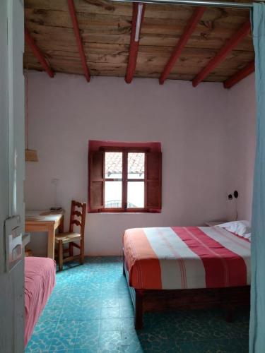 a bedroom with two beds and a desk and a window at Casa en el Centro de Taxco in Taxco de Alarcón