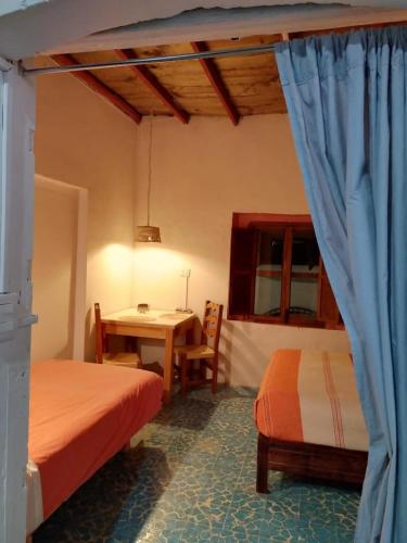 a room with two beds and a table and a table and chairs at Casa en el Centro de Taxco in Taxco de Alarcón
