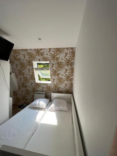 a bed with two pillows on it in a room at Cosy house 5 rooms 5 Bathrooms close commodities in Roubaix