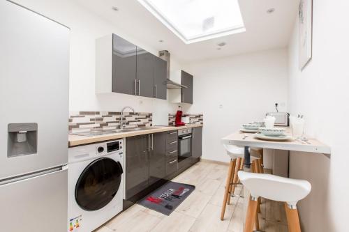 a kitchen with a washer and dryer and a table at Cosy house 5 rooms 5 Bathrooms close commodities in Roubaix
