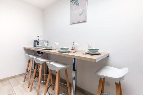 a kitchen with a counter with stools around it at Cosy house 5 rooms 5 Bathrooms close commodities in Roubaix