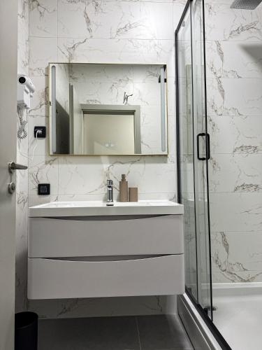 a white bathroom with a sink and a mirror at Alegria Rooms Sarajevo in Ilijaš