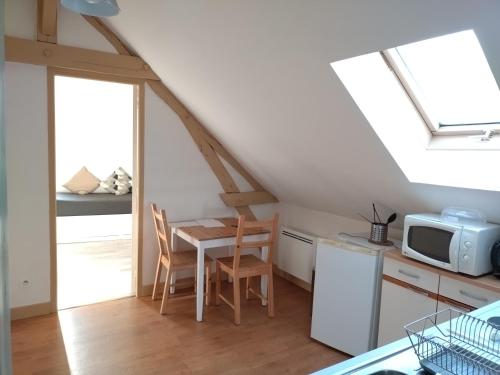 une petite cuisine avec une table et un micro-ondes dans l'établissement Cosne-sur-Loire Appartement Centre Ville, à Cosne-Cours-sur-Loire