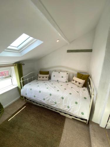 a bedroom with a white bed with pillows and a window at 5 chapel lane Wymondham Norfolk in Wymondham