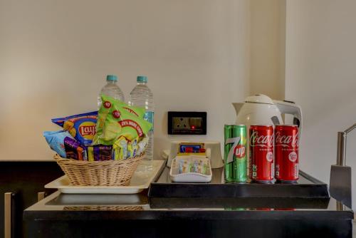 a counter top with a basket of chips and soda bottles at Quality Inn Bez Krishnaa in Visakhapatnam