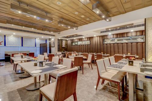 a restaurant with wooden walls and tables and chairs at Quality Inn Bez Krishnaa in Visakhapatnam