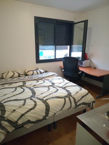 a bedroom with a bed and a desk and a chair at Studio annonay in Annonay