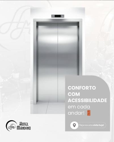 an elevator door with a sign in front of it at Hotel Mandino in Lucas do Rio Verde