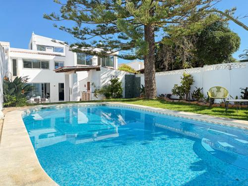 a swimming pool in front of a house at Vila Golfinho, with heated pool, rooftop lounge and ocean views in Luz