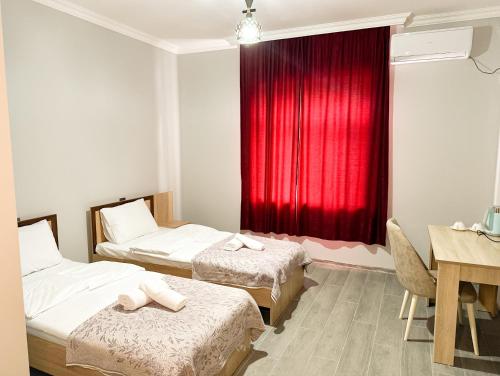 a room with two beds and a red curtain at River Garden Gabala -Rooms , Villas in Gabala