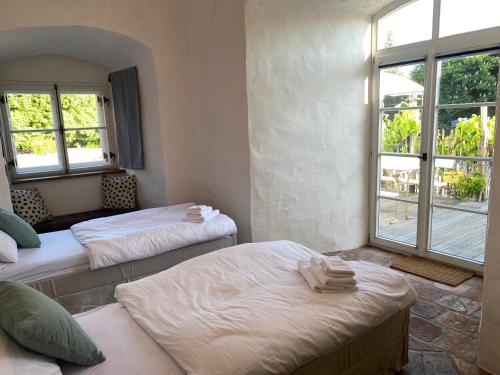 a room with two beds and a window at Glockenturm der Schlosskapelle von 1600 - Renaissance trifft auf die Gegenwart und beschert einen kunterbunten Urlaub für die ganze Familie mitten im Bayerischen Wald in Schwarzach