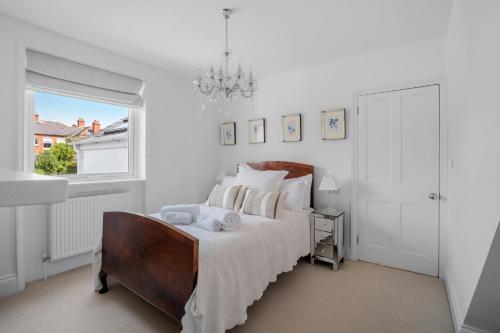 a white bedroom with a bed with towels on it at Bay View Luxury Stays - Iris Harbour Cottage in Rodwell