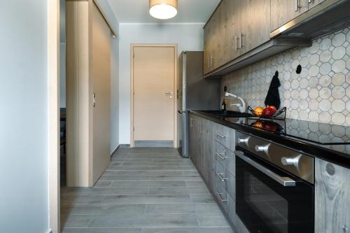 a kitchen with black counter tops and a hallway at Elymnion Horizon in Limne
