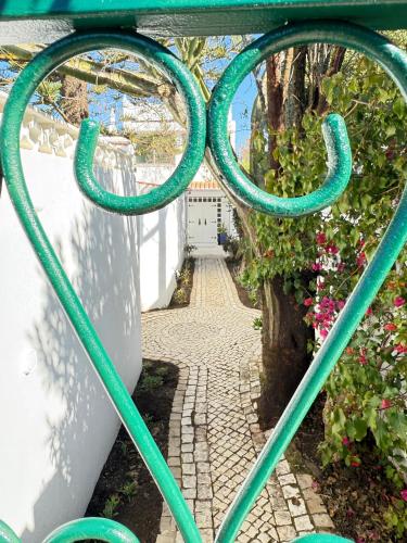 a green metal gate with a walkway at Vila Golfinho, with heated pool, rooftop lounge and ocean views in Luz