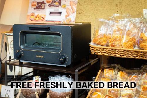 a toaster oven sitting next to a basket of bread at BaliAn Resort Chiba-Chuo in Chiba