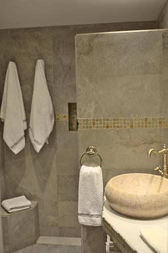 a bathroom with a sink and a shower with towels at Ático vista mar con terraza in Adeje