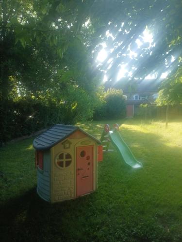 une maison de jeu avec toboggan dans l'herbe dans l'établissement Maison 4 chambres Capdenac-Gare centre - Aveyron, à Capdenac-Gare