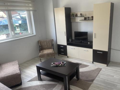 a living room with a coffee table and a tv at Like Home Central Apartment in Bitola