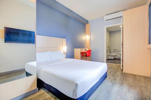 a hotel room with a bed and a bathroom at ibis Rio de Janeiro Nova America in Rio de Janeiro