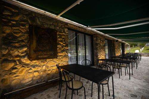 a row of tables and chairs against a stone wall at Kasollet e zanave in Pristina