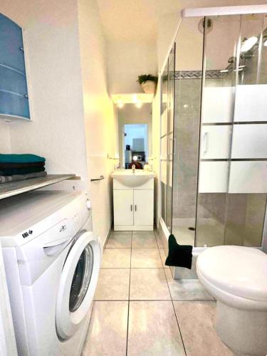 une salle de bain avec machine à laver et toilettes dans l'établissement Magnifique 2 pièces à côté de la mer, à Nice