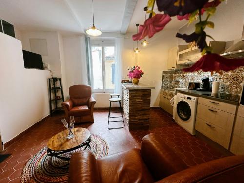 a living room with a couch and a kitchen at Coucoun Prouvençau au cœur du Village d'Allauch in Allauch