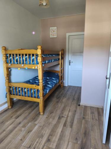 a pair of bunk beds in a room with wooden floors at La maison des Bretzels GÎTE jacuzzi et charme Alsacien in Pfaffenhoffen