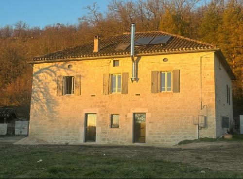 a large brick house with a solar roof at Domaine de Péroline Piscine et jacuzzi in Cézac