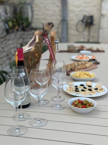 a table with wine glasses and plates of food at Domaine de Péroline Piscine et jacuzzi in Cézac