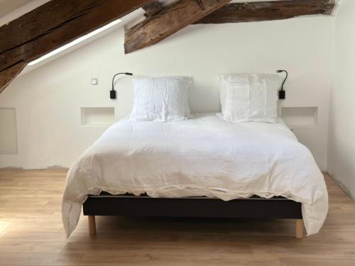 a bedroom with a large bed with white sheets and pillows at Domaine de Péroline Piscine et jacuzzi in Cézac