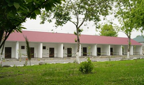 a large white building with a pink roof at River Garden Gabala -Rooms , Villas in Gabala