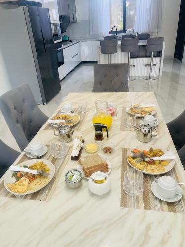 a table with plates of food on it in a kitchen at Entebbe Super Lake view basement studio in Wakiso