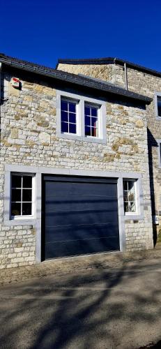 a garage door on the side of a stone house at Le Vieux Sart de Sprimont in Sprimont