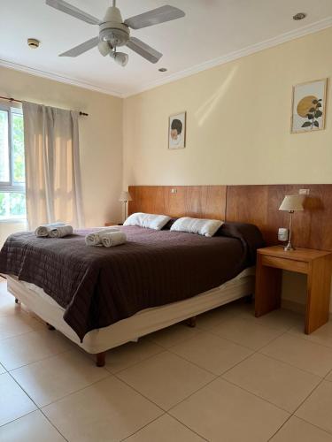 a bedroom with a large bed and a ceiling fan at Departamento en Colastine Norte in Colastiné