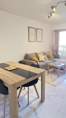 un salon avec une table et un canapé dans l'établissement Magnifique Grand 2 Pièces moderne lumineux au calme avec grande terrasse à 15mn en bus Centre-ville, Gare et Promenade des Anglais, à Nice