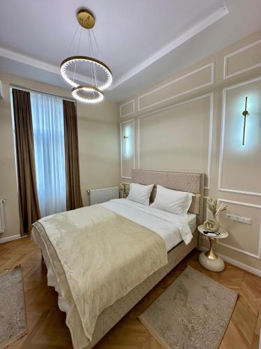 a bedroom with a large bed and a chandelier at Central View Apartment in Turda